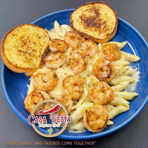 Casa Fiesta's shrimp pasta with creamy sauce, topped with parmesan cheese and two slices of garlic bread.