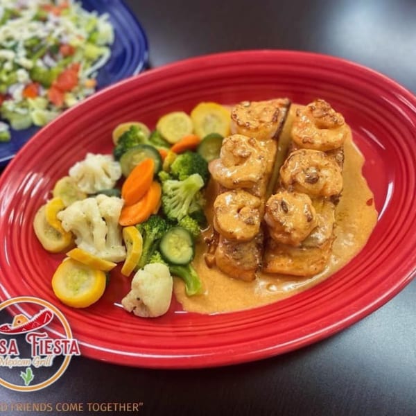 Casa Fiesta Mexican Grill's shrimp and fish dish with mixed vegetables on a red plate.