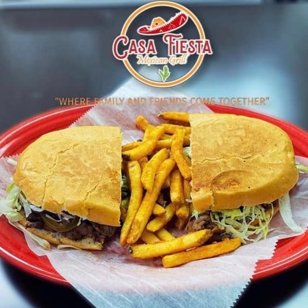 A Casa Fiesta Mexican Grill torta sandwich with fries on a red plate.